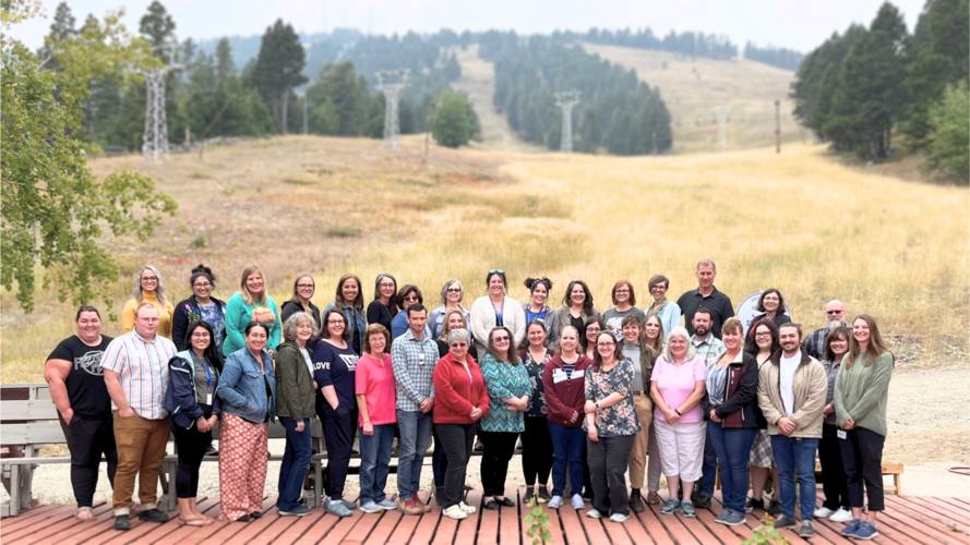The entire staff of Lewis and Clark Public Health standing against the backdrop of a mountain